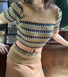 a mannequin wearing a knitted sweater and skirt in front of a radio