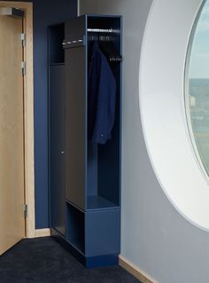 an empty blue locker next to a round window