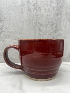 a brown coffee cup sitting on top of a white table