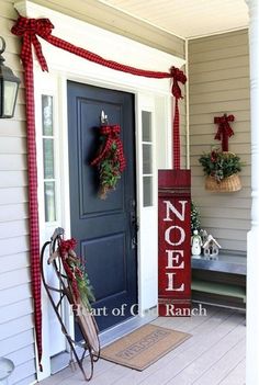 a front porch decorated for christmas with wreaths and decorations