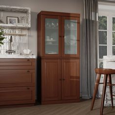 a kitchen with wooden cabinets and white counter tops next to a dining room table in front of a window