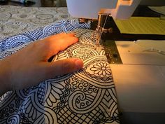 someone is using a sewing machine to sew something on a tablecloth that has been designed