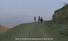 three people walking down a dirt road in the distance with a quote on it that reads well, to continue to being alive is also an art