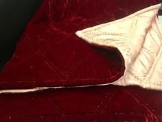 a red blanket with white stitching on it