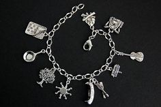 A collection of silver plated camping themed charms have been dispersed around a shimmering silver plated bracelet chain in this handmade charm bracelet. This camping charm bracelet is then completed with a lobster clasp and a 1/2 inch of chain at the end for adjustable sizing. Charms in this bracelet include a sleeping bag charm, pan charm, tree charm, sun charm, canoe charm with oars charm, camp sign charm, guitar charm, backpack charm, and campfire charm. ● Sizing ● To determine your bracelet Handmade Themed Silver Charm Bracelet, Handmade Themed Silver Bracelet, Handmade Charm Bracelets, Bracelet Summer, Camping Signs, Camp Counselor, Sun Charm, Silver Plated Bracelet, Backpack Charm