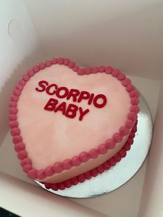 a heart shaped cake with the words scorpio baby written on it in red icing