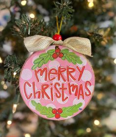 a merry christmas ornament hanging from a tree