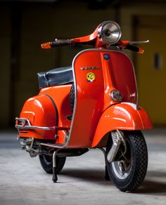 an orange motor scooter parked in a garage