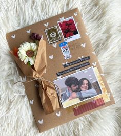 a brown envelope with some pictures and flowers on the inside is tied up to it