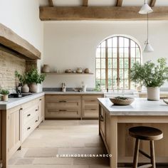 a large kitchen with wooden cabinets and white counter tops, an arched window over the sink