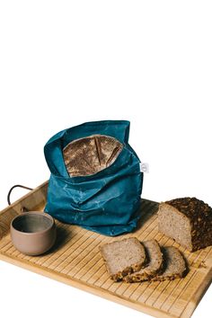 bread and other food items on a bamboo tray with a blue bag over it,