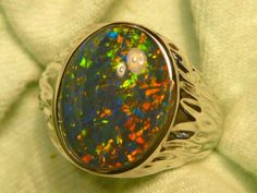 "As a rule the very best & highest quality stones are strictly reserved for our 14ct Gold range. Occasionally I set a few of the very best stones in the Sterling Silver range, this is one of those occasions. If you are prepared to pay a premium for the very best quality Opal , without the extra expense of a Solid Gold setting, this could suit. The ring is made from Sterling Silver & is Semi \"J\" backed with ornate workings. The Gem Plus grade Triplet Opal is 16x12mm Oval & of the highest qualit Classic Oval Opal Ring Collectible, High Luster Oval Gemstones For Gifts, Elegant Untreated Oval Opal Ring, Elegant Oval Untreated Opal Ring, Silver Range, Southern Cross, Opal Ring, Natural Opal, Opal Rings