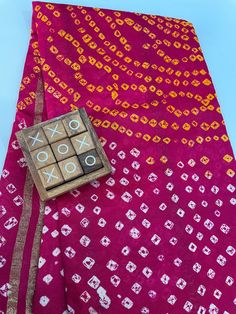 Beautiful Silk Saree with Bandhani print . Suitable for every occasion.  Saree Material ------Art Silk  Color ---------Rani bright pink  Saree length -------5.50 m  Blouse --------unstitched  Blouse meters --------0.9 m  Work of sareee------  Bandhani print with Zari Pallu n Gota Border.  🥰 Fall and piko already done .  🥰 Ready to wear .  🥰 Dry clean wash as it is Handmade Bandhani saree ( Original) , not machine printed.  Occasions: Wedding Wear, Party Wear, Festive Wear, Durga Puja, Indian Wear, Sangeet Wear, Bridal Wear, Chrismas Day, Mothers Day, Haldi Wear, karwachauth.  NOTE *Actual color may vary slightly from your monitor. *We dispatch the product within 2 weeks after Confirmation of Payment Received. PLEASE FEEL FREE TO CONTACT US FOR ANY FURTHER QUERY. Thank you! Pink Pre-draped Saree With Printed Border For Wedding, Pink Bandhani Print Pre-draped Saree For Festivals, Wedding Choli With Printed Border For Festivals, Wedding Choli With Printed Border, Traditional Festive Choli With Printed Border, Navratri Semi-stitched Bandhani Blouse Piece, Multicolor Choli With Printed Border For Festivals, Traditional Choli With Printed Border And Traditional Drape, Semi-stitched Bandhani Blouse Piece For Navratri