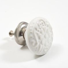 a close up of a white door knob on a white surface with an intricate design