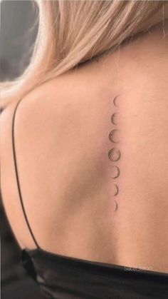 the back of a woman's shoulder with three phases on it