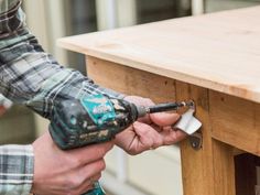 a person using a power drill to attach a piece of wood on top of a table