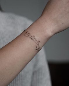 a woman's arm with a small flower tattoo on the left side of her wrist