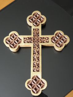 a decorative wooden cross on a black surface