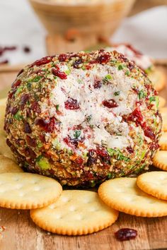 a cheese ball on top of crackers with cranberries and other toppings