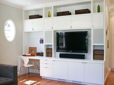 a living room with white shelves and a flat screen tv on top of it's entertainment center