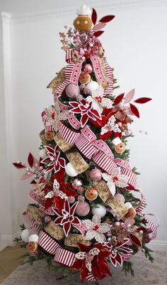 a decorated christmas tree with red and white ribbons