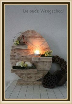 a wooden shelf with some plants on it and a lit candle in the center that says de oude wegeschaal