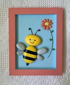 a yellow and black bee sitting in front of a pink frame with a flower on it