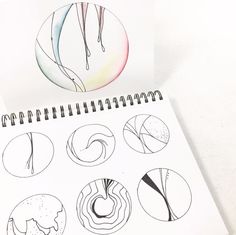 a spiral notebook with drawings of different shapes and sizes on the page next to it