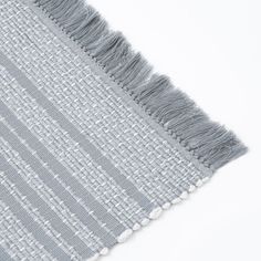 a close up view of a gray and white rug with fringes on the side