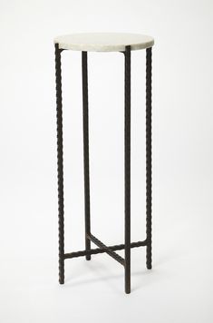 a white marble top table with black metal legs and an iron frame on the base