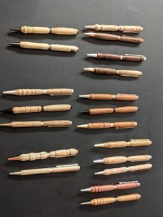 several different types of wood carving tools lined up on a black surface with white tips