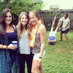 three women standing next to each other in the grass