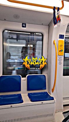 the inside of a subway car with two blue seats and a yellow sticker on it