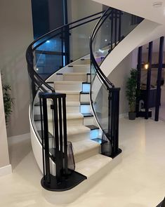 a white staircase with black railing and glass balustrees in a modern home