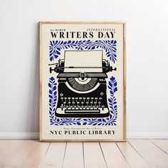 an old fashioned typewriter's day poster on a wooden frame in front of a white wall