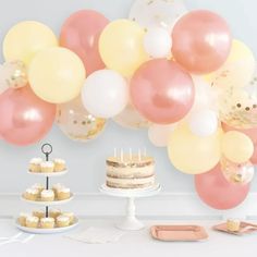 a table with cake, cupcakes and balloons