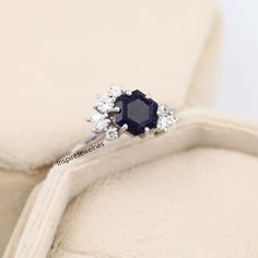 a diamond and blue sapphire ring sitting on a cushion