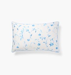 a white pillow with blue flowers on the front and back, against a white background