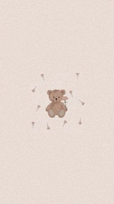 a brown teddy bear sitting on top of a white wall next to dandelions