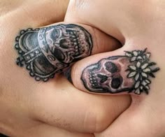 two fingers with skulls and flowers on them