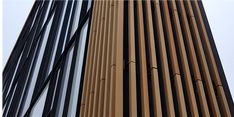 the side of a tall building with black and brown lines on it's sides