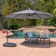 an umbrella over a chair next to a pool