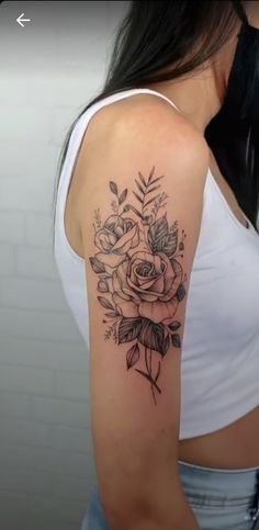 a woman's arm with a rose tattoo on the left side of her shoulder