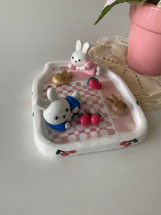 a small tray with some toys on top of it next to a potted plant