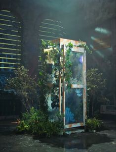 a tall metal box with plants growing out of it