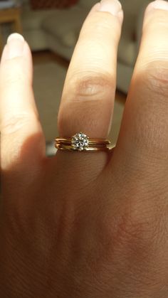 a woman's hand with a diamond ring on it