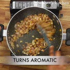 someone is frying onions in a wok on the stove top with a spatula