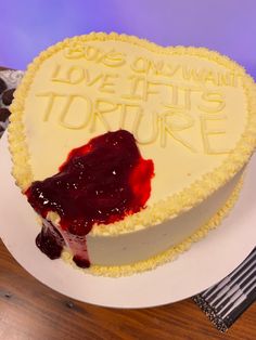 a heart shaped cake sitting on top of a white plate next to a knife and fork