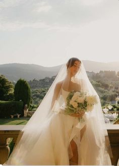 a woman in a wedding dress standing on a balcony