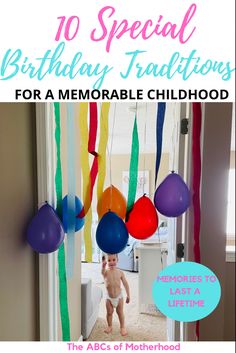 a baby standing in front of a doorway with balloons and streamers hanging from the ceiling